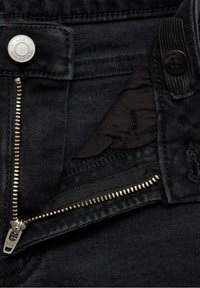 Černé džínové kalhoty s kovovým knoflíkem v pase, YKK zipem a měkkou podšívkou, které představují klasický design.