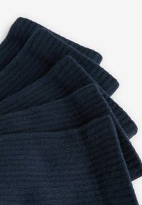 Tessuto blu navy a costine con una consistenza morbida, strati sovrapposti che mostrano linee verticali chiare e una leggera peluria sui bordi.