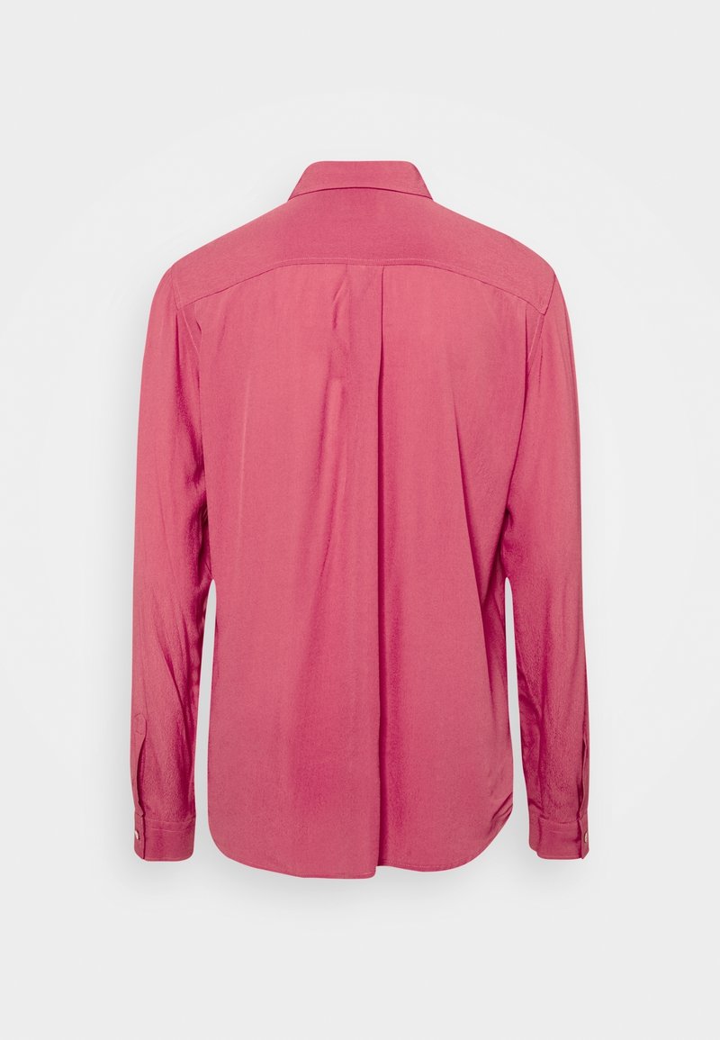 Chemise à manches longues en tissu rose pâle. Présente un col classique, un pli au dos et des poignets à boutons. Texture lisse avec une coupe décontractée.
