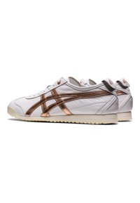 Sneakers bianchi in pelle con dettagli in rosa oro metallico e design a tre strisce. Suola in gomma testurizzata con dettaglio del tallone in contrasto.