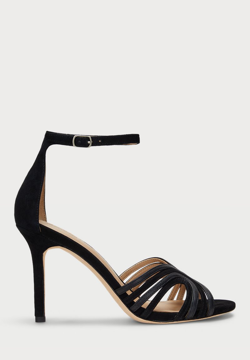Μαύρη σουέτ σανδάλι με ψηλό τακούνι και σχέδιο πολλαπλών λουριών, με κούμπωμα στον αστράγαλο και λεία, μπεζ σόλα. Κομψά σχηματισμένος τακούνι για στήριξη.