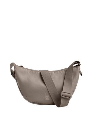 Light brown crescent-shaped crossbody bag with adjustable wide strap and small "GOT BAG" logo on front.