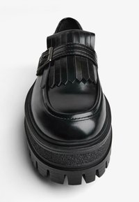 Fekete bőr öltönycipő, vastag talppal, frufru részletekkel és csattal a tetején. Simára csiszolt felület.