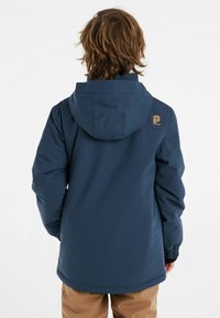 Giacca impermeabile blu navale con cappuccio, polsini elasticizzati e un piccolo logo sulla spalla. Trama liscia, vestibilità casual e design di lunghezza medio.