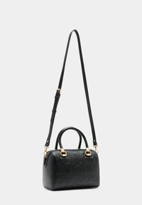 Sac à main noir structuré en cuir texturé, avec des appareils en métal doré, des poignées doubles et une bandoulière réglable.