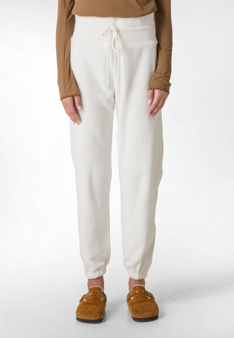 Cremefarbene Fleece-Sweatpants mit einem gerippten hohen Bund und verstellbarem Kordelzug, mit schmal zulaufenden Knöcheln und weichem Material.