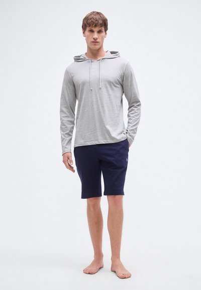 Camisola com capuz de manga comprida cinza claro com cordão, combinada com calções azul-marinho escuro. O tecido parece macio, com um corte descontraído e detalhe mínimo de logótipo.