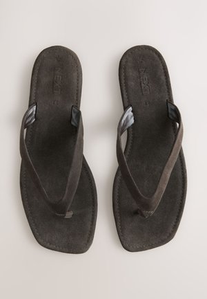 Pruunidest seemisnahast plätud lame tallaga, millel on tekstuuriga rihmad ja lihtne disain. Täiendavaid mustreid ega aksente pole.