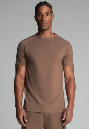 Brun kortærmet t-shirt lavet af blødt stof med rund halsudskæring og subtile logo detaljer. Det tætsiddende design forbedrer bevægelsesfriheden.