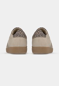 Μπεζ σουέντ αθλητικά παπούτσια με τακούνι σε σχέδιο λεοπάρ. Επίπεδη λαστιχένια σόλα, ομαλή υφή και πλαϊνές ρίγες σε φωτεινότερο μπεζ.