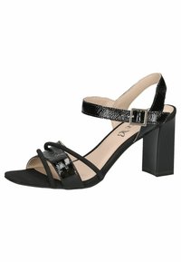 Sandalele cu toc negre au un superior din piele sintetică lucioasă, cu un design cu barete, un brâu pentru gleznă cu cataramă și un toc pătrat pentru susținere.