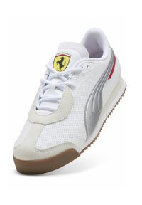 Hvide sneakers med perforeret overdel, grå accenter og røde detaljer. Har en sål af gummirubber og et gult Ferrari-logo på tungen.
