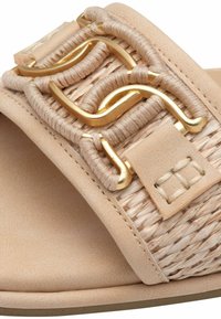 Sandal beige con una larga fascia in tessuto intrecciato, dettagli in metallo dorato e una finitura liscia e opaca sulla suola resistente.