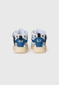 Witte en blauwe sneakers met een textuur aan de achterkant, voorzien van muzikale noot patronen en een retro design. Lichtgekleurde zool met merkaccenten.