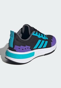 Čierna športová obuv s tyrkysovými akcentmi, fialovými pixelovanými detailmi, textúrovaným zvrškom a bielou medzipodrážkou. Obsahuje výrazné logo Adidas.