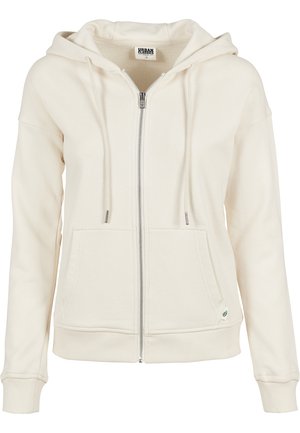 Huvtröja med dragkedja i mjuk beige bomull. Har en rymlig framficka, snörning vid huvan och ribbade ärmslut med en liten logotagg.