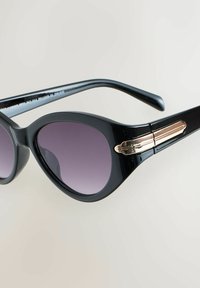 Occhiali da sole neri a forma di occhi di gatto con lenti sfumate viola. Caratterizzati da dettagli in metallo dorato vicino alle aste e montatura in plastica lucida.
