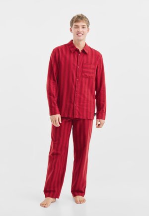 Gestreiftes Pyjama-Set in Rot, gefertigt aus leichtem Stoff. Enthält ein Hemd mit Knöpfen und Tasche, lange Ärmel und passende gerade geschnittene Hosen.