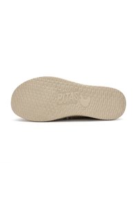 Beige rubber shoe sole with textured pattern, featuring an embossed logo and a round shape, designed for traction and comfort.