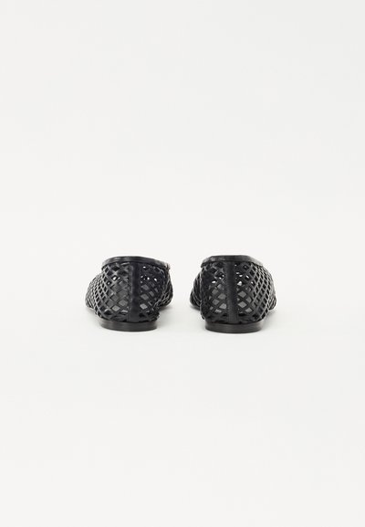 Black woven slip-on shoes with a flexible design, flat soles, rounded toes, and an open mesh pattern for breathability.