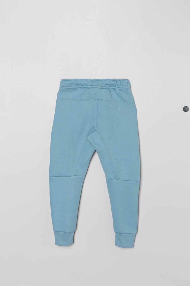 Jasnoniebieskie spodnie dresowe wykonane z miękkiego materiału, z prążkowanym pasem, zwężającymi się nogawkami i detalami szwów dla lepszego kroju.
