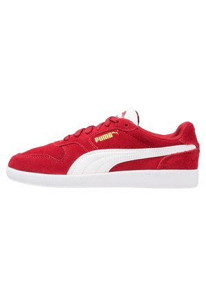 Czerwony zamszowy sneaker Puma z białą podeszwą, białym bocznym paskiem, złotym logo Puma, niskim krojem i białym językiem, widziany z boku.