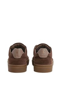 Zapatillas de ante marrón con un acabado texturizado, puntera redondeada y suela de goma en tono marrón claro. Presenta un logo en la lengüeta del talón.