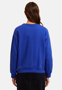 Blauer Baumwollpullover mit lockerer Passform, geripptem Kragen und Ärmelbündchen sowie einer glatten Textur. Der Saum ist leicht verkürzt.
