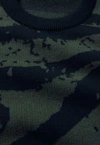 Strickpullover mit einem Tarnmuster in Dunkelgrün und Schwarz. Gerippter Rundhalsausschnitt und strukturierte Oberfläche. Weicher, elastischer Stoff.