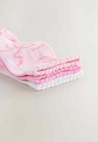 Tre paia di calze impilate. Due sono rosa solido con un leggero motivo, e una è bianca solida con bordi testurizzati, tutte in materiale lavorato a maglia.
