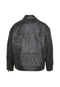 Giacca in pelle nera con una vestibilità strutturata, cuciture visibili, design oversized e polsini con zip. Texture liscia e minimalismo nei dettagli sul retro.