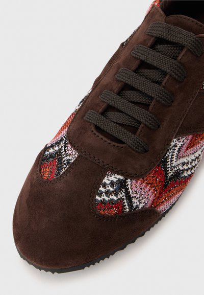 Baskets en daim marron avec un motif textile tissé multicolore avec des accents rouges, noirs et blancs ; lacets ronds et semelle texturée.
