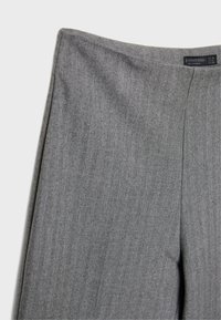 Grijze broek met visgraatmotief, gladde textuur en gestructureerde tailleband, voorzien van een verborgen voorzijde sluiting en plooi-details.