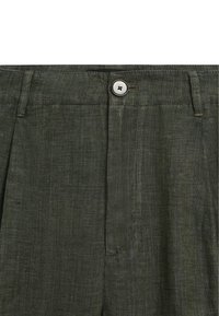 Pantalon en lin vert avec une fermeture à un bouton et une coupe avant plate, présentant une texture subtile et des plis cousus sur mesure.