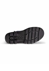 Suola di scarpa in gomma nera con un motivo di grip testurizzato, caratterizzata da un logo circolare e sezioni contornate per flessibilità e trazione.