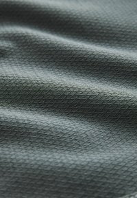 Textured fabric in dark green with a diamond pattern, showcasing a smooth surface and subtle sheen.