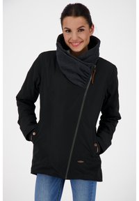 Musta takki vetoketjulla, jossa on suuri harmaa kaulus ja sivutaskut, valmistettu sileästä ja pehmeästä materiaalista. Koristeena ruskeat napit.