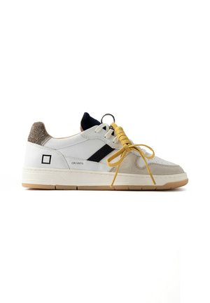 Sneaker bianca low-top con dettagli in camoscio beige, striscia nera, lacci gialli legati a fiocco e suola in gomma beige su sfondo bianco.