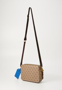 Borsa a tracolla marrone con motivo, chiusura con zip, accessori in oro, tracolla regolabile marrone scuro e un'etichetta blu attaccata.