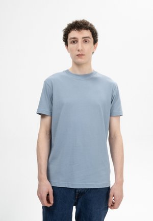 Lichtblauwe crewneck t-shirt van zachte stof, met korte mouwen en een standaard pasvorm. Draag het met donkerblauwe denim jeans, die een eenvoudig ontwerp en kleurcontrast tonen.