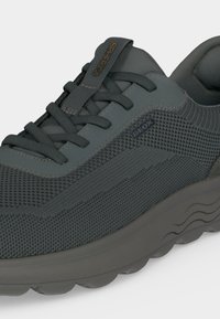 Chaussure de sport gris foncé en tissu texturé, lacets noirs, étiquette "SPHERICA" sur la languette et logo "GEOX" sur le côté.