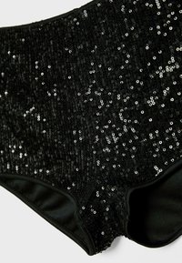 Czarne szorty z cekinami o wysokim stanie z prążkowaną teksturą, z połyskującymi, okrągłymi cekinami na całej powierzchni i gładkim wewnętrznym podszyciem.