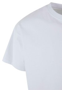 Hvid bomulds t-shirt med rund halsudskæring og korte ærmer. Glat tekstur, afslappet pasform, synlige stikninger ved kanterne.
