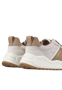 Sneakers beige e grigi con un materiale scamosciato testurizzato e una finitura liscia, caratterizzati da una suola bianca spessa, logo embossato e accenti a contrasto.