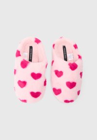 Pink fuzzy slippers with light pink base, featuring darker pink heart patterns. Closed-back design, soft texture, and padded interior.