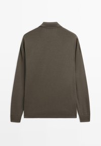 Langarm-Polohemd aus dunklem Olivenstoff mit einem klassischen Kragen, gerippten Bündchen und einem geraden Saum ohne sichtbare Logos.