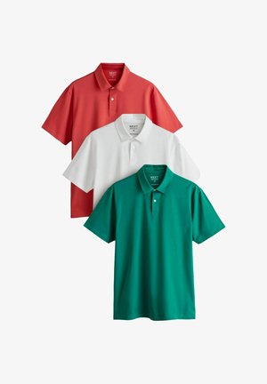 Trzy średniej wielkości koszulki polo w kolorach czerwonym, białym i zielonym, ułożone w przesuniętym stosie.
