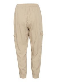 Beige cargo kalhoty s elastickým pasem, zúženými nohavicemi a bočními kapsami. Vyrobeno z lehkého, texturovaného materiálu.