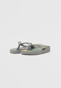 Sive japanke s uzorkom na ulošku koji sadrži šarene dizajne. Tanke trake s teksturiranom površinom i zlatnim "Havaianas" logom.
