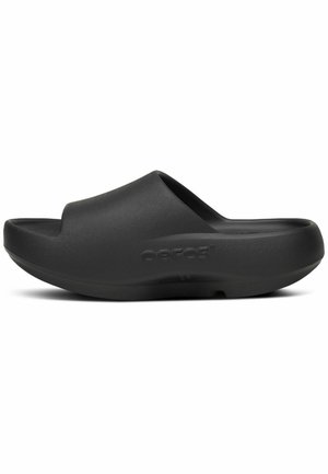 Sort slip-on slide sandal med tyk polstret sål og åben tå, med et buet ergonomisk design og "Oofos"-logo på siden.